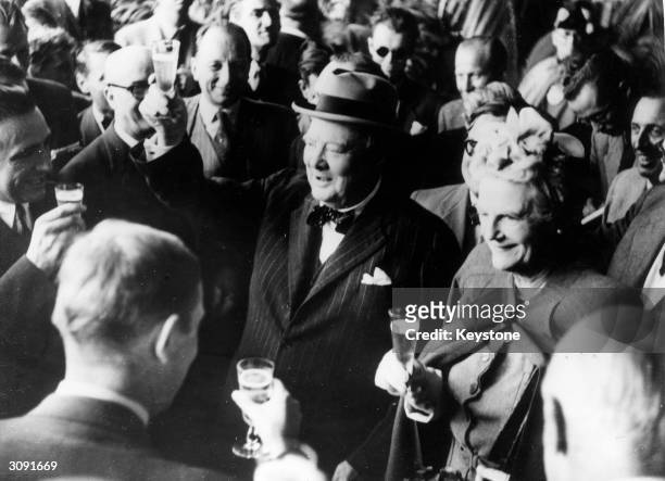 Former British prime minister Winston Leonard Spencer Churchill and his wife Clementine make a toast upon their arrival in Switzerland.