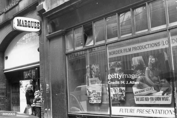 Marquee Club entrance in Wardour Street, Soho, London next to Border Film Productions' window with a poster showing a bare-breasted woman.