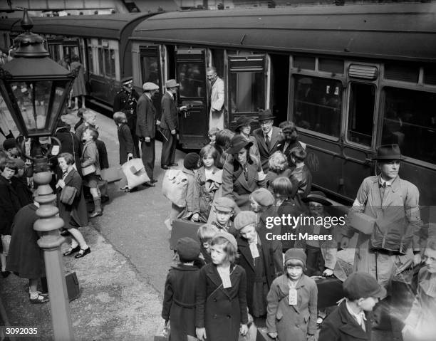 Trainload of schoolchildren with labels round their necks arrive at Pontypool, Monmouthshire railway station from Birmingham. They are the first...