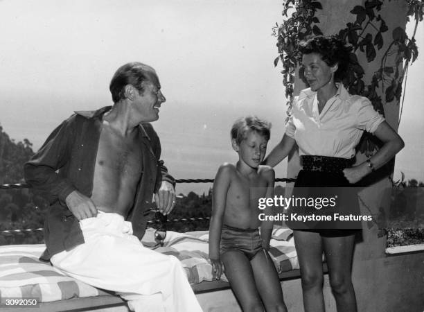 British actor Rex Harrison with his wife, actress Lilli Palmer and their son Kerry on the verandah of their villa overlooking the Gulf of Portofino.