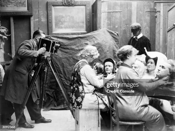 Cameraman films a couple of women as they craft waxwork heads for a new exhibition at Madame Tussaud's museum in London.