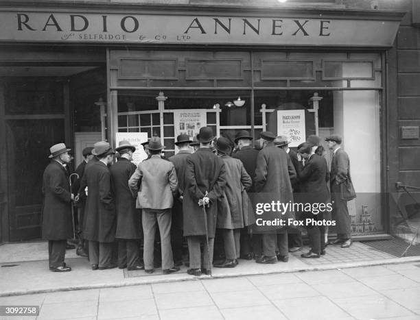 Crowd gathers at Selfridges, London, to read about a demonstration of an early wireless machine used for sending messages.