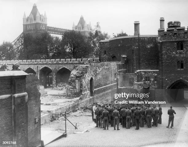 Group of soldiers inspecting bomb damage at the Tower of London.