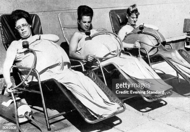 Three pregnant women relax in medical 'space-suits' in an attempt to ease childbirth and raise the intelligence of their offspring. A suction pump...