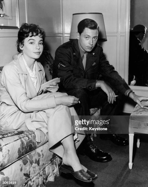 French actress Leslie Caron relaxes between takes with American actor John Kerr, her co-star in the upcoming movie 'Gaby'.