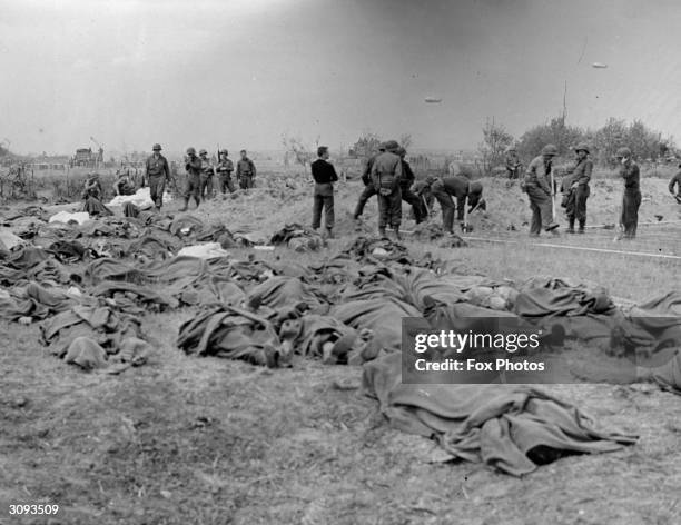 The bodies of American soldiers lie on the ground in Normandy, France, awaiting burial, following the D-Day Allied invasion.