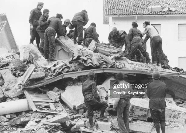 Italian soldiers and civilians trying to dig out bodies from under the debris after an earthquake in the village of Gemona del Friuli killed more...