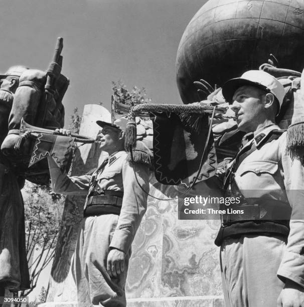 Legionnaires blowing their trumpets in front of the monument to the French Foreign Legion in the outpost at Sidi-Bel-Abbes, where their headquarters...