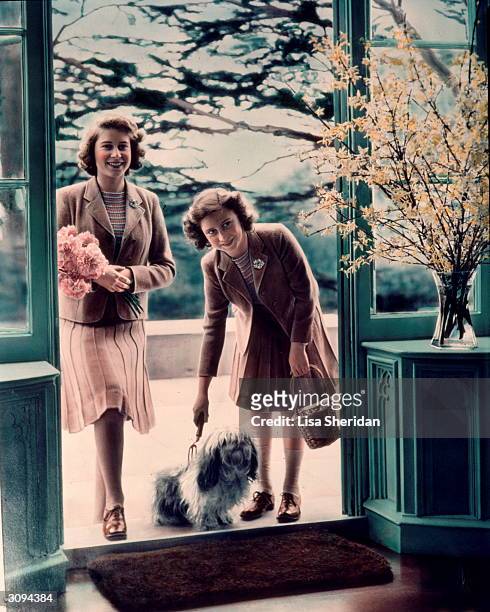 Princesses Elizabeth and Margaret Rose with one of their lhaso apso dogs outside the Royal Lodge, Windsor.