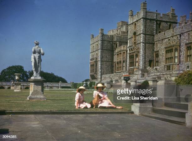 Princesses Elizabeth and Margaret Rose sunbathing outside Windsor Castle, Berkshire.