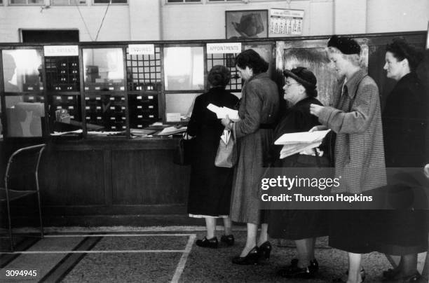 National Health patients queue at the outpatients' department in St Bartholomew's Hospital, London. Original Publication: Picture Post - 7333 - You...