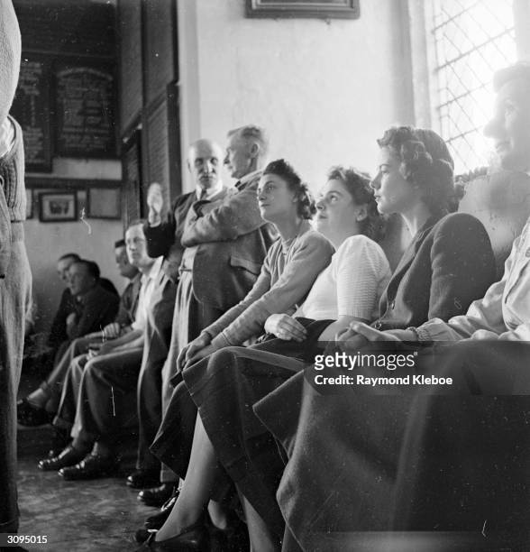 The audience listen, entranced to a performance of bell ringing of Lavenham Church in Suffolk. Original Publication: Picture Post - 4827 -...
