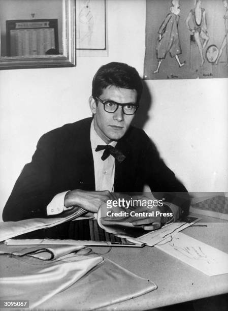 Yves Saint-Laurent ex-wonder boy of Dior examining swatches of material in his office near the Champs-Elysees where he is to open up his own fashion...