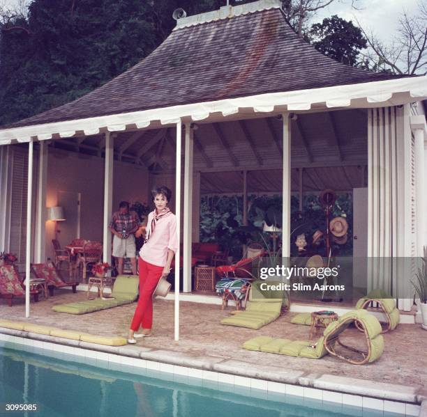 Babe Paley by the pool. Her husband, William Paley is snapping the photographer at their cottage, Round Hill, Jamaica. A Wonderful Time - Slim Aarons