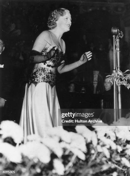 Singer Gracie Fields at the microphone.