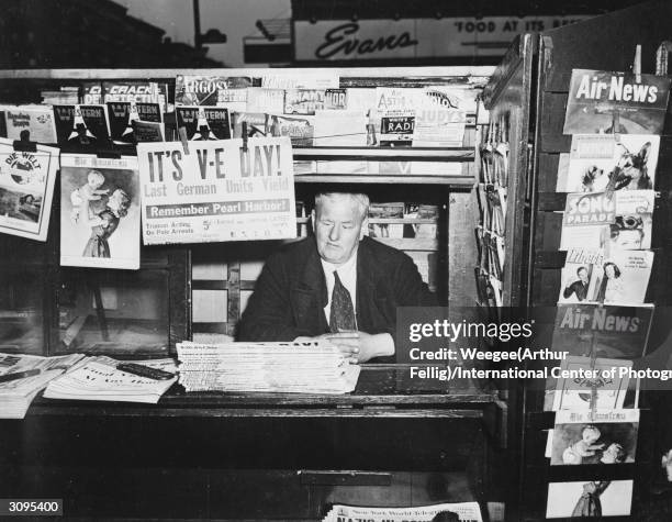 Publication at a news-stand in America announces the surrender of the last German units on V-E Day, signalling Victory in Europe.