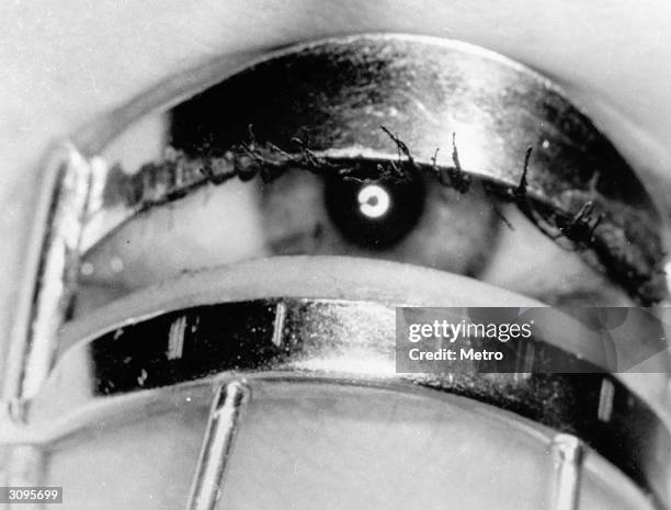 Woman uses an eyelash curler as part of her daily beauty routine.