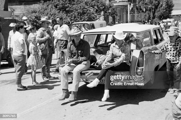 American actor Clark Gable sits on the boot of a car on the set of John Huston's 'The Misfits', filming on location in the Nevada Desert.