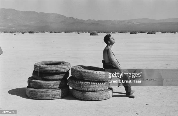 Magnum photographer Elliott Erwitt resting in the sun during the filming of 'The Misfits' on location in the Nevada Desert.