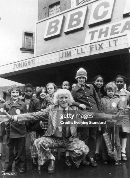 English radio disc jockey, television broadcaster and charity worker Jimmy Savile with some of the children who will be taking part in his new series...