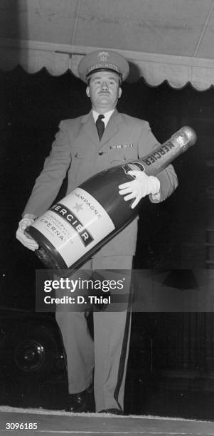 Methuselah of Mercier champagne being carried by a concierge at the Savoy hotel, London.