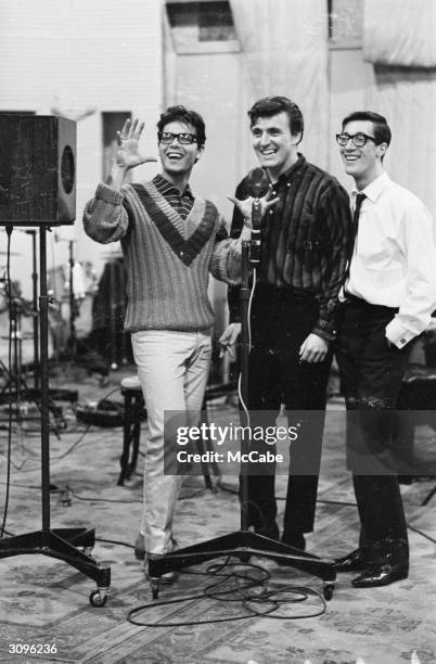 On the left pop singer Cliff Richard, at the EMI recording studios. In the centre is Bruce Welch, rhythm guitarist and on the right, Hank Marvin lead...