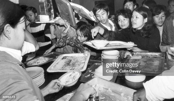 Vietnamese refugees clamouring for food at breakfast time in their hostel.