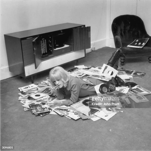 British disc jockey and television presenter, Annie Nightingale, relaxing at her home in Brighton with some of her records, including albums by the...