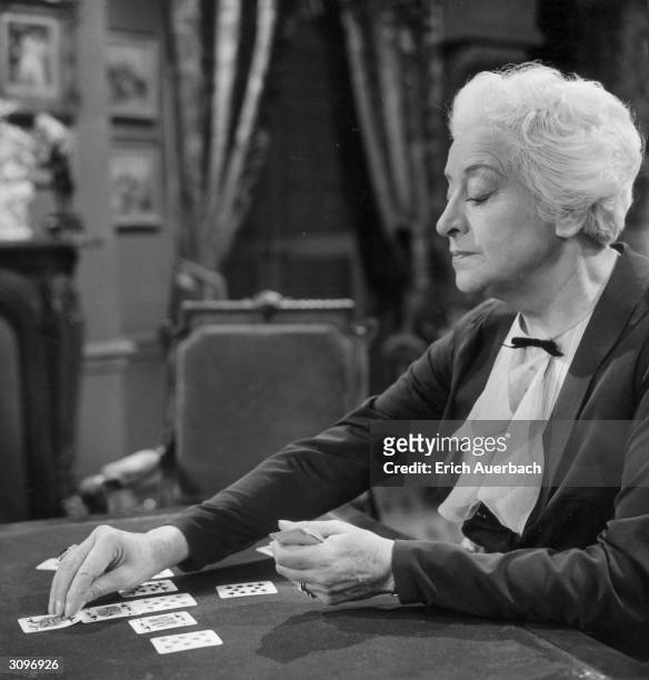 Actress Francoise Rosay plays a game of solitaire in the BBC television drama, 'Solitaire'.