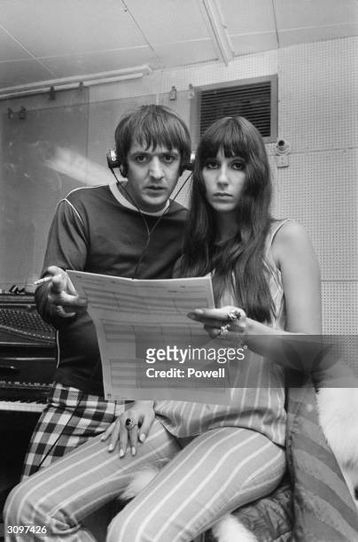 American husband and wife pop singers, Sonny Bono and Cher, in a recording studio during a session in aid of the Braille Institute.