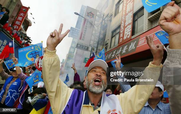 Supporters of Taiwan's presidential opposition candidate Lien Chan cheer on March 16, 2004 while campaigning in the city of Hsinchu, Taiwan. Both the...