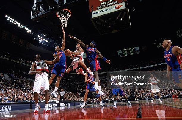 Damon Stoudamire of the Portland Trail Blazers shoots a layup over Ben Wallace and Corliss Williamson of the Detroit Pistons at The Rose Garden on...