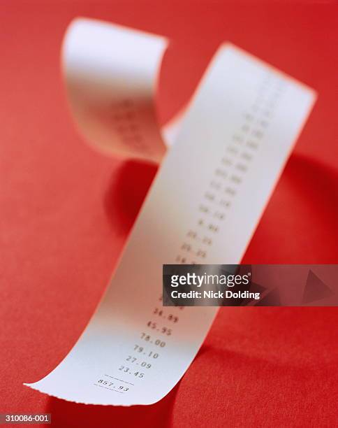 adding machine receipt coiled on red background, part blurred effect - adding machine tape stock pictures, royalty-free photos & images