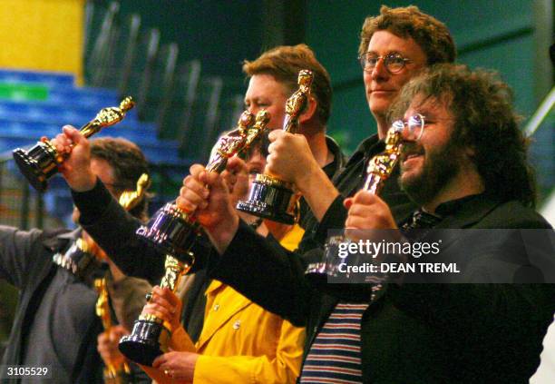 Lord of The Rings director Peter Jackson with Richard Taylor Michael Hedges and other Oscar winners on stage with their Academy Awards in front of...