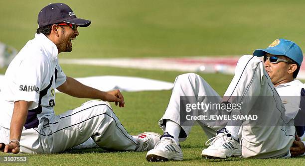 Indian cricket captain Sourav Ganguly shares a light moment with teammate Sachin Tendulkar during a practice session at the Arbab Niaz Stadium in...