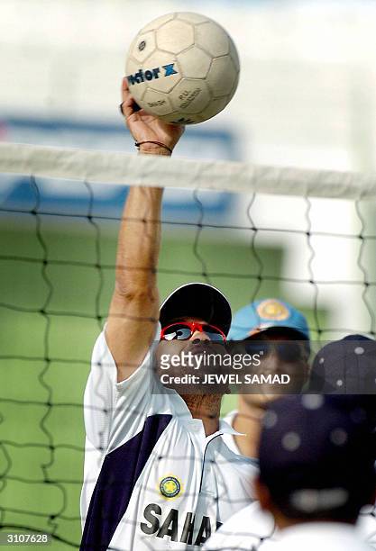 Indian cricket team captain Sourav Ganguly watches as teammate Sachin Tendulkar plays a shot during a volleyball game with teammates at the Arbab...