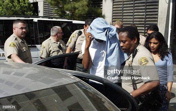 Police escort a group of people believed to be family members of Marcus Wesson from the courthouse on March 18, 2004 in Fresno, California. Wesson's...