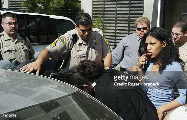 Police escort a group of people believed to be family members of Marcus Wesson from the courthouse on March 18, 2004 in Fresno, California. Wesson's...