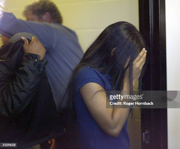 Serafino Wesson, the son of Marcus Wesson and an unidentified girl shield their faces from the media March 18, 2004 in Fresno, California while on...
