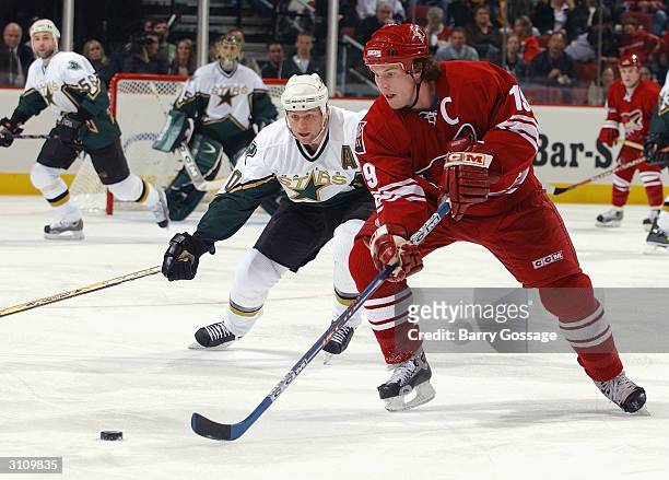 Right wing Shane Doan of the Phoenix Coyotes moves the puck against Brenden Morrow of the Dallas Stars during the game on February 14, 2004 at...