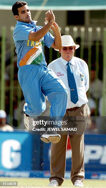 Indian pace bowler Zaheer Khan delivers a ball as English umpire David Shepherd looks on during the third One Day International match between...