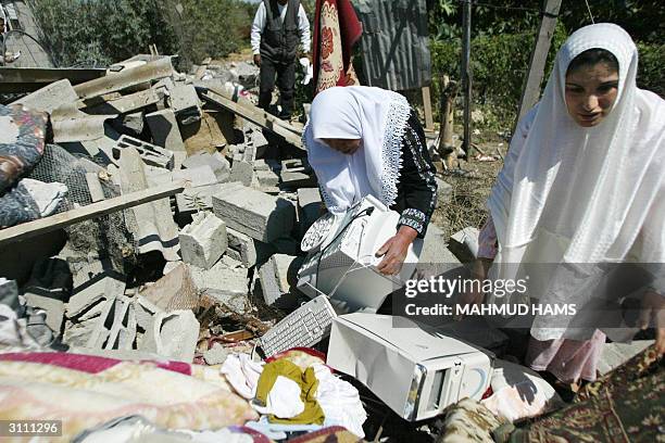 Palestinian women salvage a computor from the rubble of their home demolished by Israeli troops during their week-long incursions into the Gaza Strip...