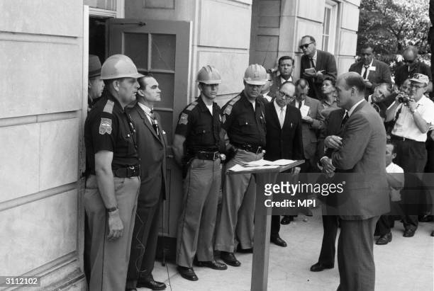 June 11 Tuscaloosa, AL: George Wallace, the Democratic Governor of Alabama, standing in the doorway of the administrative building of the University...