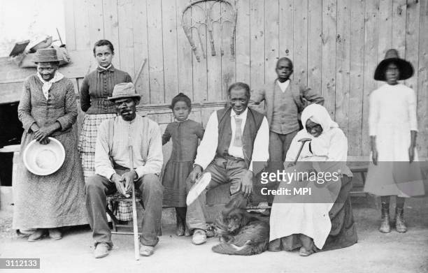Portrait of American abolitionist Harriet Tubman as she poses with her family, friends, and neighbors on her porch, Auburn, New York, mid to late...
