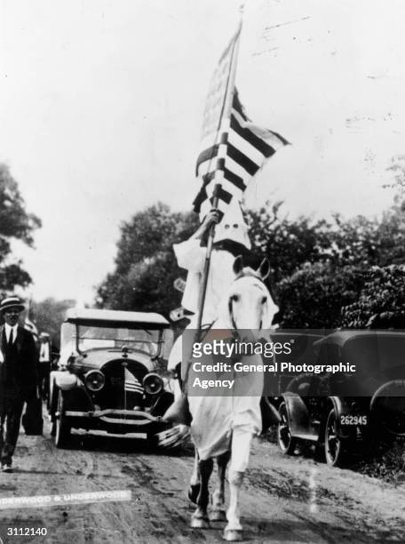 Member of the Ku Klux Klan carrying an American flag during a klan parade in Niles, Ohio.