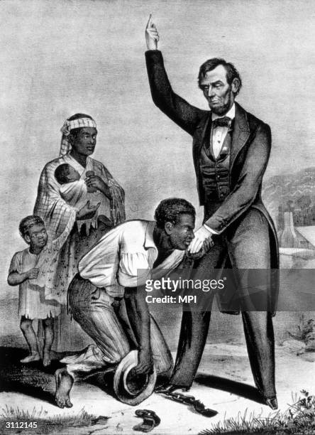 Watched by his family, a freed formerly enslaved man, his shackles at his feet , kisses the hand of President Lincoln.