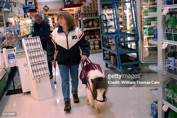Shari Bernstiel is helped through a supermarket by Tonto, her guide horse March 19, 2004 in Lansdale, Pennsylvania. Tonto, a miniature horse who went...