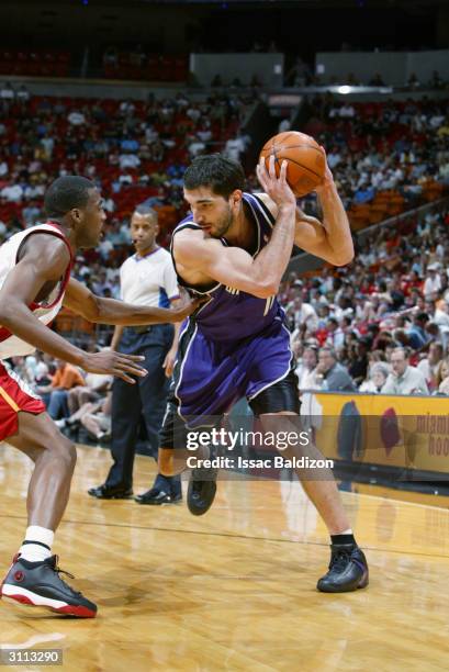 Predrag Stojakovic of the Sacramento Kings looks to drive on Eddie Jones of the Miami Heat during the game on March 6, 2004 at American Airlines...