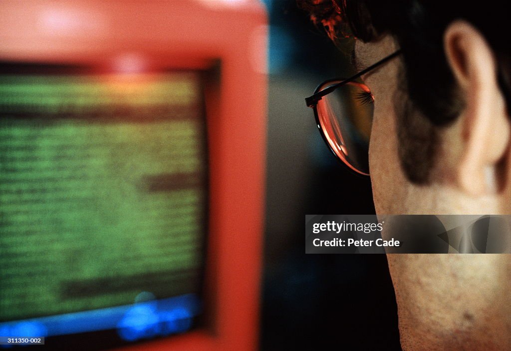 Back view of man looking at computer screen