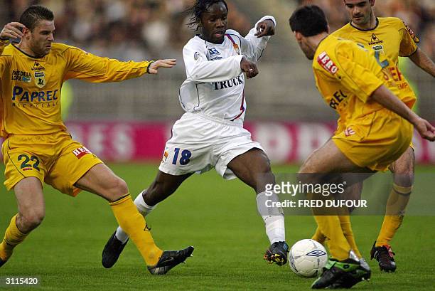 Lyon's forward Peguy Luyiundula vies with Nantes defenders Sylvain Armand and Loic Guillon during their French L1 football match, 20 march 2004 at...